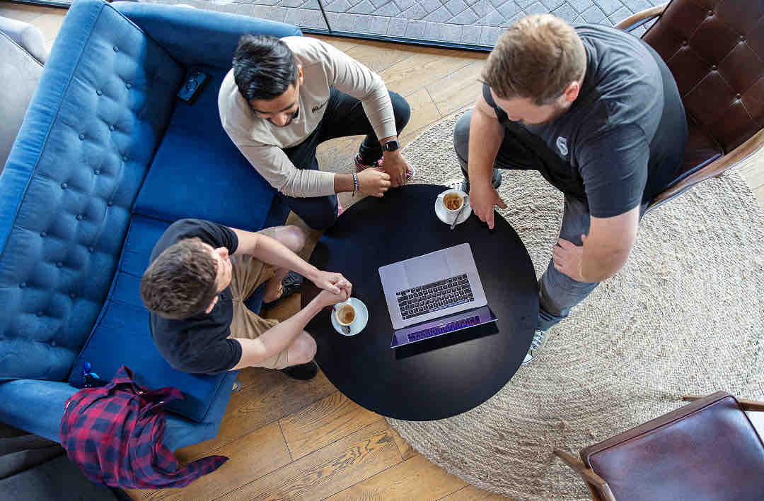 3 people sitting at a coffee table in a birds eye view